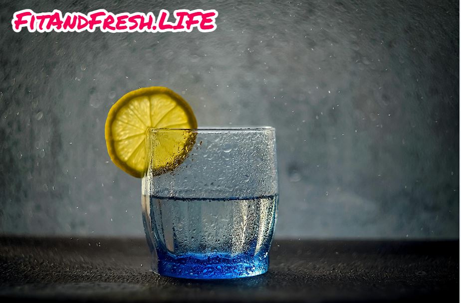 A glass of water with cutted lemon piece